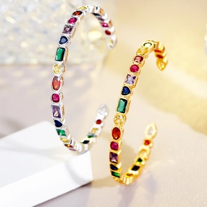 Detail of silver and gold open bracelets featuring multi-colored geometric zircons