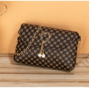 Detail of dark brown leather mini bag with gold chain strap and pearl charms