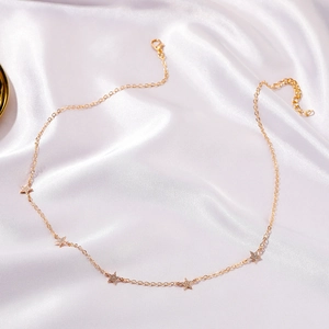 Choker minimalista in oro con cinque ciondoli a stella scintillanti su seta bianca