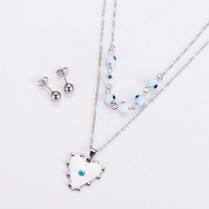 Detail of silver double-layer necklace with blue evil eye heart pendants and stud earrings