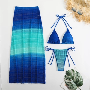 Dettaglio della maglia all'uncinetto di un set bikini a tre pezzi con gonna sfumata blu