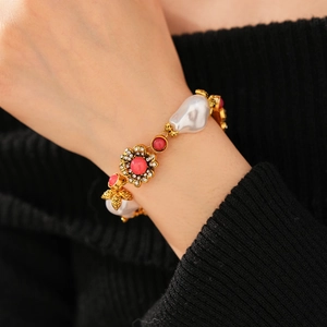 Macro view of vintage gold bracelet with baroque pearls and crystal flower charms