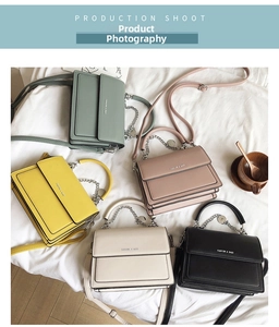 Detailed top view of five textured flap bags with metal handles and chain straps