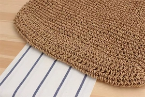 Macro shot of the intricate tan hollow-out hand-woven texture on the straw beach bag