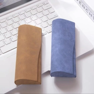 Close-up of minimalist triangle fold eyewear cases in brown and blue nubuck leather