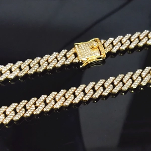Macro detail of 12mm gold-plated hip hop Cuban link chain with sparkling crystals