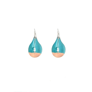 Detail of drop-shaped turquoise enamel earrings with pearl accents and gold finish