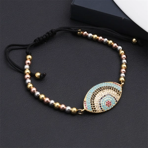 Macro shot of evil eye bracelet with colorful zircons and black woven cord