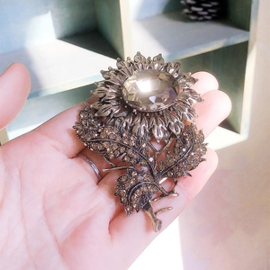 Vintage sunflower brooch with brown crystals and large multifaceted center gemstone