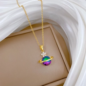 Macro shot of gold-plated Saturn pendant with colorful crystal and white rhinestones