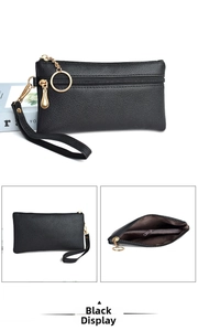Detail view of black lychee grain rectangle wristlet with golden hardware and zipper pocket