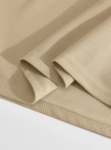 Gros plan détaillé sur la texture du tissu gaufré kaki et la couture de l'ourlet