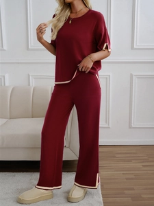 Detail showing burgundy knit set with cream contrast piping on sleeve and side slits