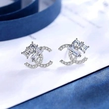 Detailed view of silver-tone hoop earrings with crystals and rectangular gemstones