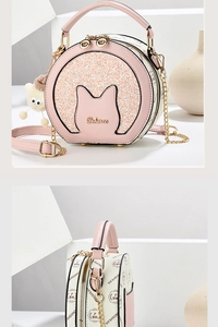 Detail of pink cat-ear round bag featuring sequin finish and decorative pompom charm