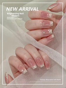 Close-up of pink jelly press-on nails with white French tips, pearls and rhinestones