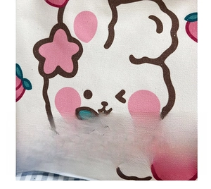 Close-up of canvas bag featuring cute cartoon rabbit and hand-drawn peach prints