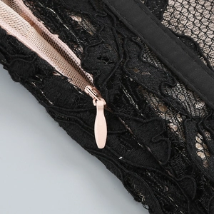 Gros plan de dentelle noire avec fermeture éclair rose invisible et détails fins
