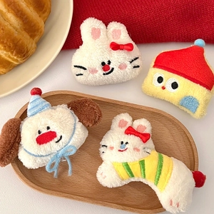 Close-up of cute plush dog and rabbit hair clips on a cozy wooden tray setting