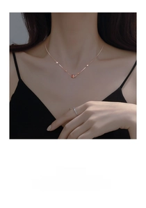 Macro shot of rose gold geometric necklace with five colorful beads and zircon accents