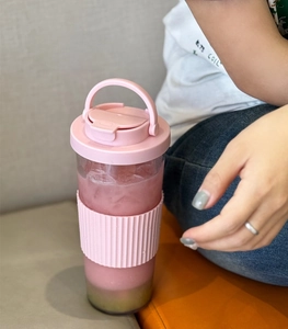 Pink Tritan boba straw cup with hidden handle and silicone sleeve in lifestyle setting