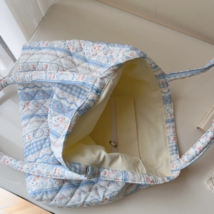 Internal view of floral quilted tote bag showing cream canvas lining and zipper pocket