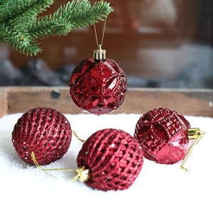 Dark red Christmas ornaments with geometric relief and gold glitter on snow