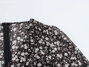 Detail view of the floral dress shoulder with small floral print, size S tag, and zipper