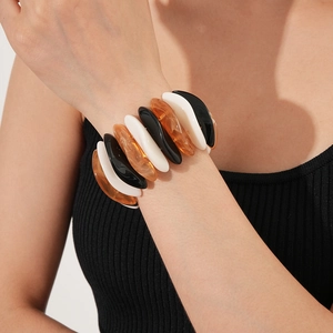 Close-up of geometric stretch bracelet with black white and amber resin segments