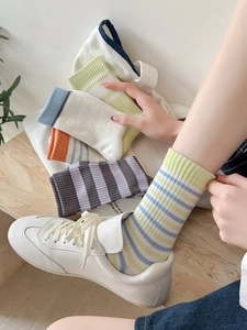 Texture de tricot détaillée de chaussettes en coton à rayures sur un sol en bois