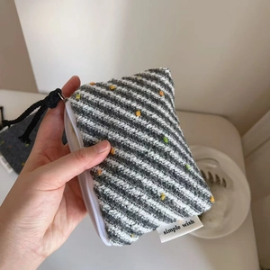 Dettaglio mini portamonete in lana a righe con pompon colorati e chiusura lampo