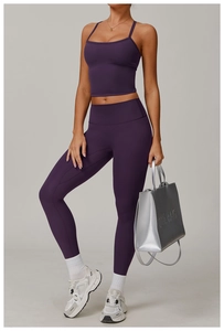 Detailed view of dark purple athletic yoga top and high-waisted leggings with matte finish