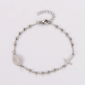 Detail of silver rosary bracelet featuring cross and Virgin Mary medal charms