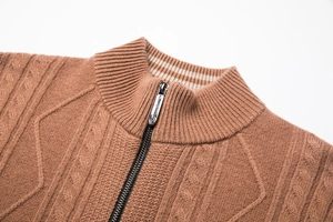Detailed close-up of camel knit sweater standing collar and metallic zipper texture