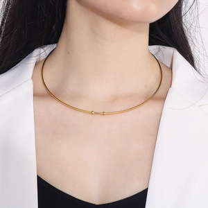 Gros plan d'un tour de cou doré en C minimaliste avec deux perles porté par un mannequin