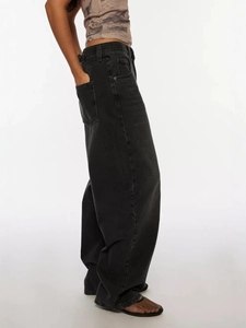 Washed black high street style wide-leg denim jeans for women shown from a side profile angle