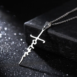 Silver stainless steel cross necklace featuring faith word pendant on black surface