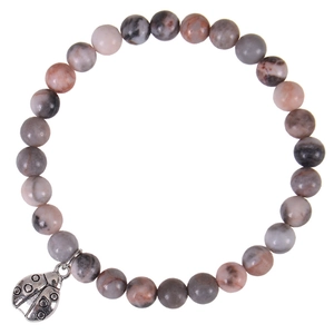 Macro detail of 6mm pink zebra stone beads with a silver ladybug charm bracelet