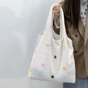 Close-up of white plush tote bag with colorful polka dots and soft fleece texture