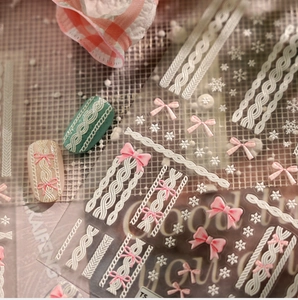 Macro view of 3D embossed nail stickers with knit textures, bows, and snowflake patterns