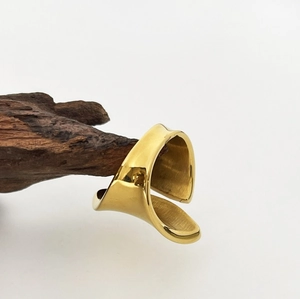 Polished 18K gold chunky open ring with asymmetrical twisted design on vintage wood base