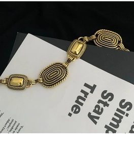 Gros plan de la ceinture chaîne dorée vintage avec textures corde et finitions métalliques