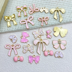 Macro shot of assorted pink and gold enamel bow charms for DIY jewelry making