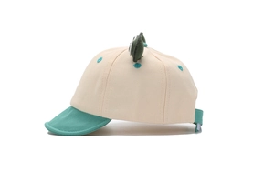 Detail of adjustable strap and cute green 3D frog eyes on a beige baby baseball cap