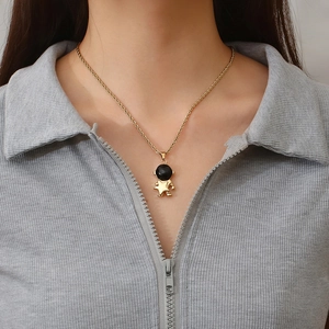 Couple's gold astronaut necklace with moon and star pendant on a twist chain link
