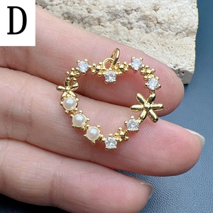 Macro detail of heart pendant with pearls and zircon stones on 18k gold plated frame