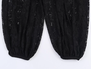 Gros plan sur la texture de la dentelle noire et les motifs en résille du pantalon