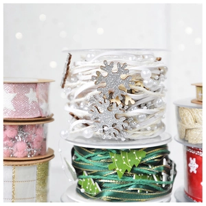 Macro view of Christmas ribbons with glitter snowflakes and green pine tree beads