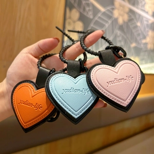 Three colorful heart-shaped leather keychains in orange, blue, and pink with black rings