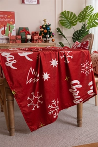 Detailed view of red velvet Christmas tablecloth with snowflake and tree patterns
